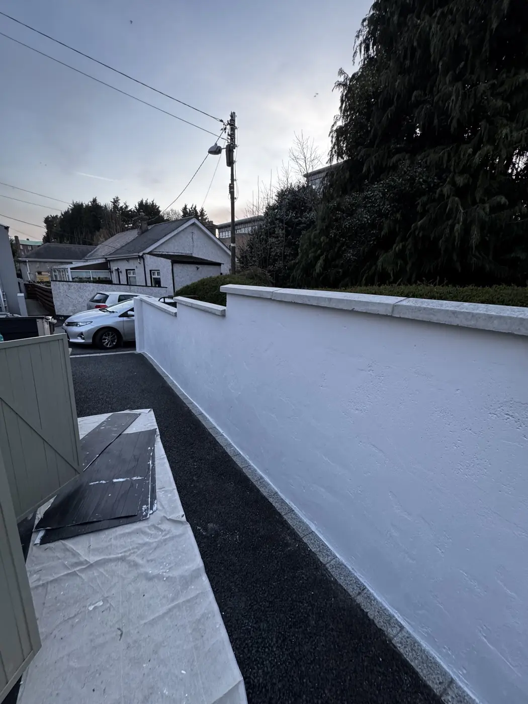 Long freshly painted white exterior garden wall in Dublin